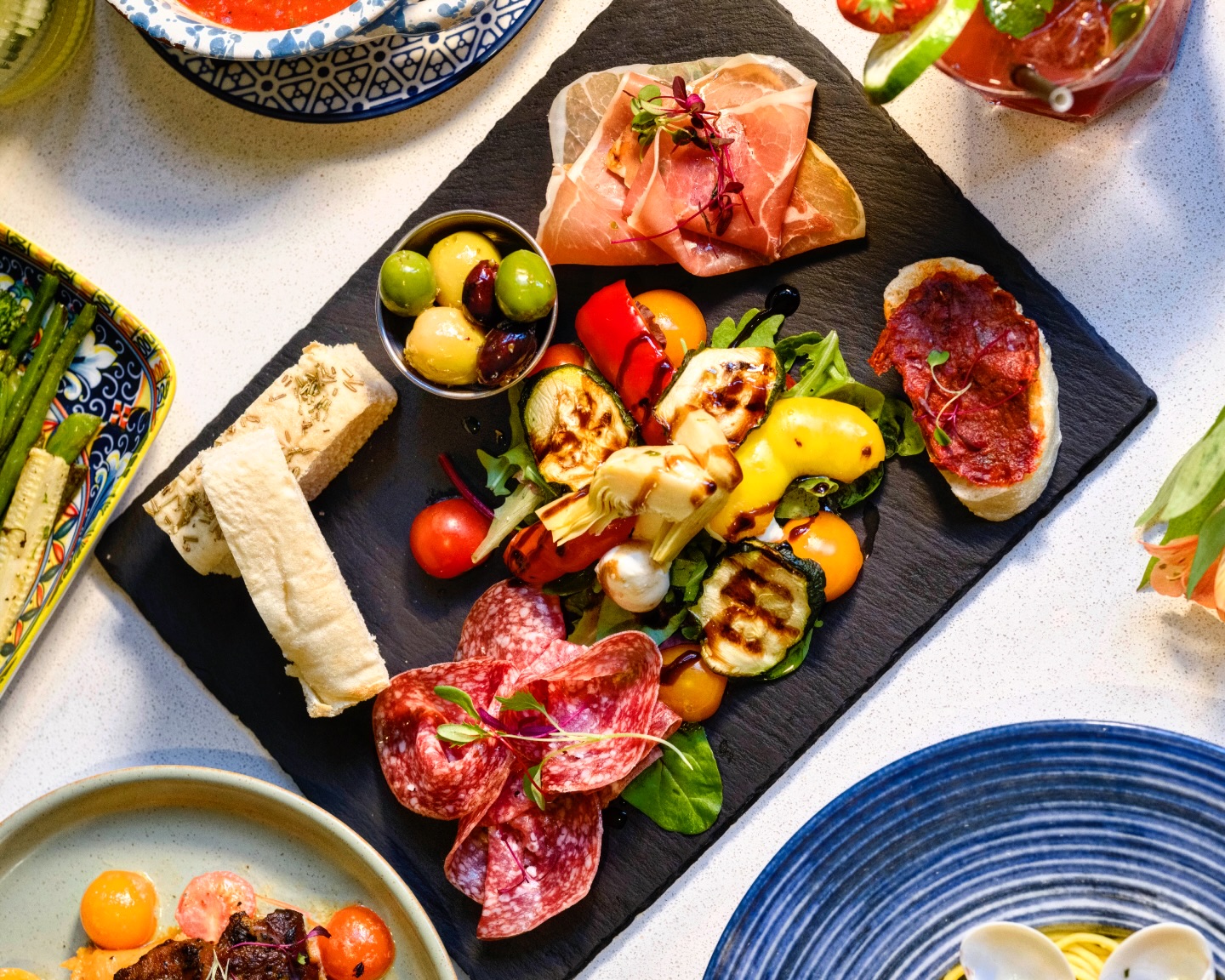 Italian cured meats, focaccia, olives and grilled vegetables arranged for sharing at Italiano Vero